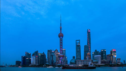 Skyscrapers in city against blue sky
