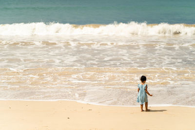 Rear view of girl looking at sea shore