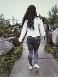 Rear view of woman standing against trees