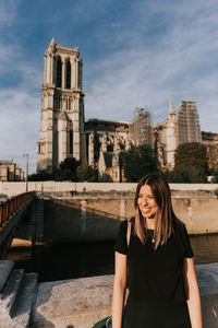 Portrait of smiling woman standing against the sky