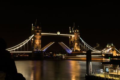 View of bridge over river at night