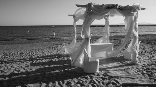 Deck chairs on beach against sky