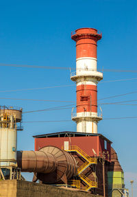 Low angle view of factory against blue sky