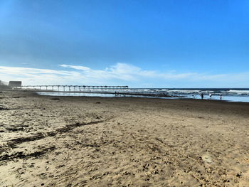 Scenic view of beach against blue sky