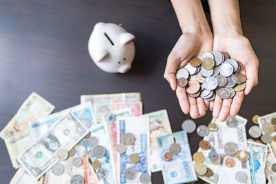 High angle view of hand holding coins