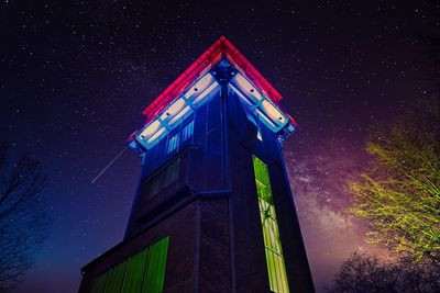 Low angle view of illuminated building against sky at night