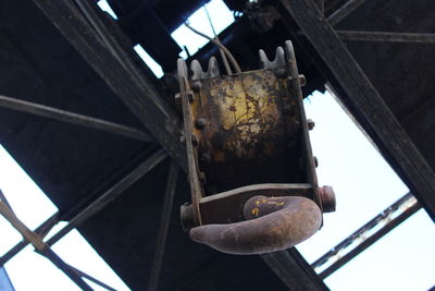Low angle view of old rusty metal hanging