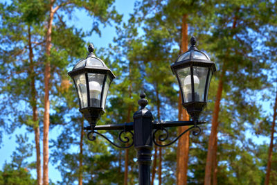 Low angle view of street light against trees