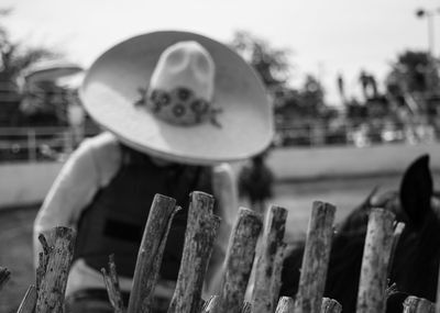 Close-up of hat on railing against sky