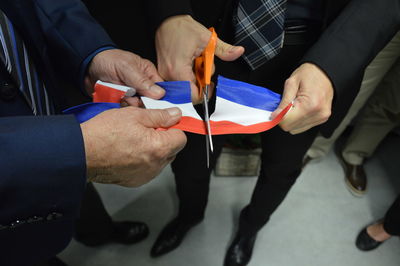 Low section of people cutting thai flag