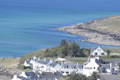 High angle view of houses by sea against sky