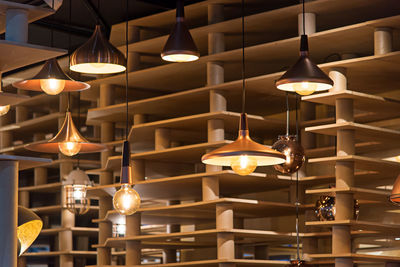 Low angle view of illuminated pendant lights hanging in restaurant
