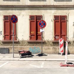 No parking sign on road against building on sunny day