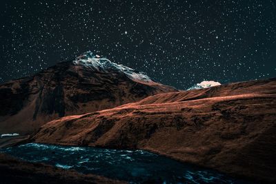 Scenic view of snowcapped mountains against sky at night