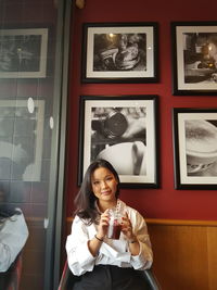 Portrait of a smiling young woman holding drink