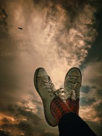 Low section of man flying against sky