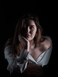 Portrait of beautiful woman against black background
