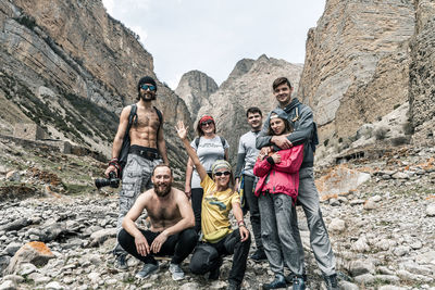 Portrait of people on rock against mountains
