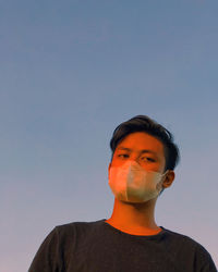 Portrait of young man against clear sky