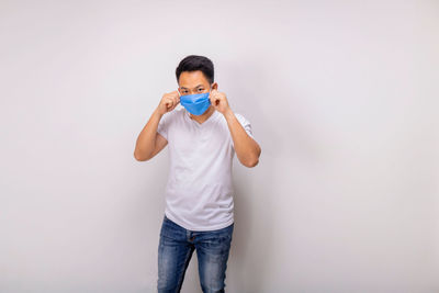 Full length portrait of man standing against white background