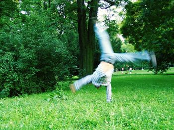 Full length of man doing cartwheel on grass