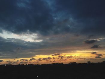 Silhouette landscape against dramatic sky during sunset