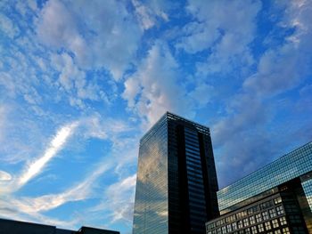 Low angle view of modern building against cloudy sky