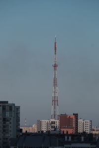 Communications tower and buildings against clear sky