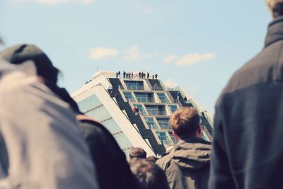 Rear view of people in city against sky