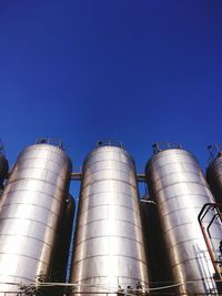 Low angle view of smoke stack against clear blue sky