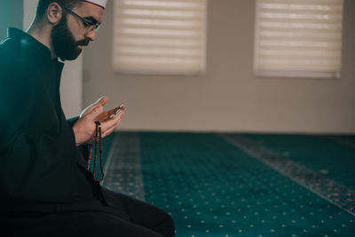 Side view of young man using mobile phone