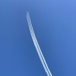Low angle view of vapor trail against blue sky