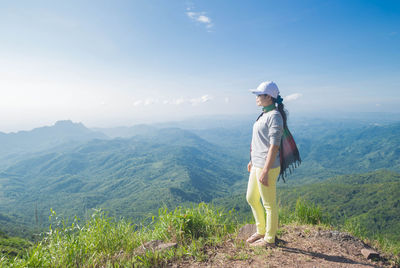 Full length of woman standing on mountain against sky