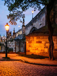 Street amidst buildings against sky at dusk