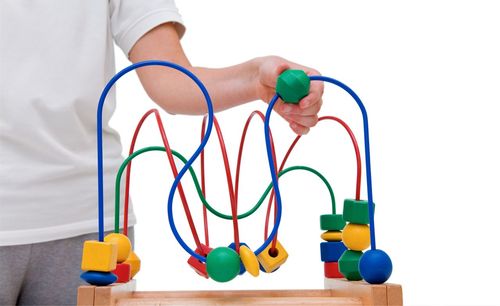 Low section of person with toys against colored background
