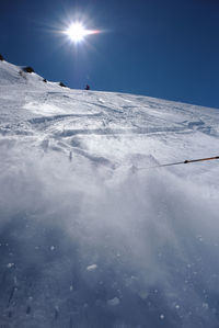 View of people skiing on snowcapped mountain against sky