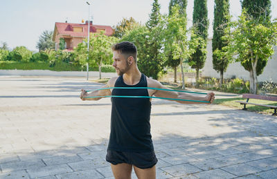 Full length of young man standing on footpath