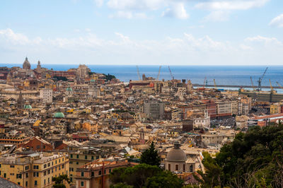 High angle view of townscape by sea against sky