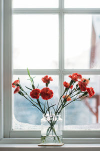 Flower vase on window sill at home