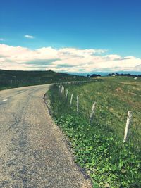 Country road against cloudy sky