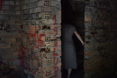 Woman standing against graffiti wall