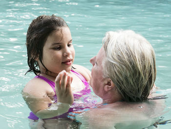 High angel view of grandmother with granddaughter in swimming pool