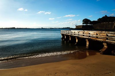 Pier on beach against sky