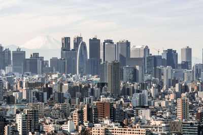 Aerial view of buildings in city against sky