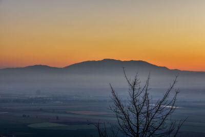 Scenic view of silhouette mountain against orange sky