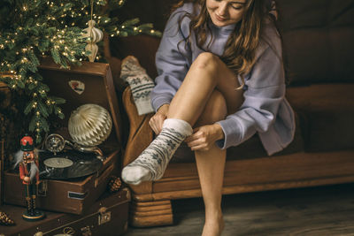 Close-up of female feet in white christmas socks with ornament. new year celebration, vinyl records