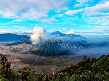 View of volcanic mountains against cloudy sky