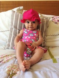 Portrait of cute baby girl on bed at home