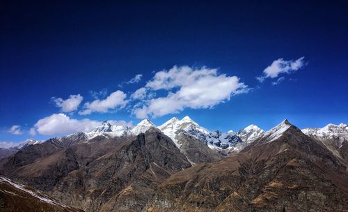 Scenic view of snowcapped mountains against blue sky