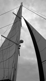 Low angle view of mast against cloudy sky